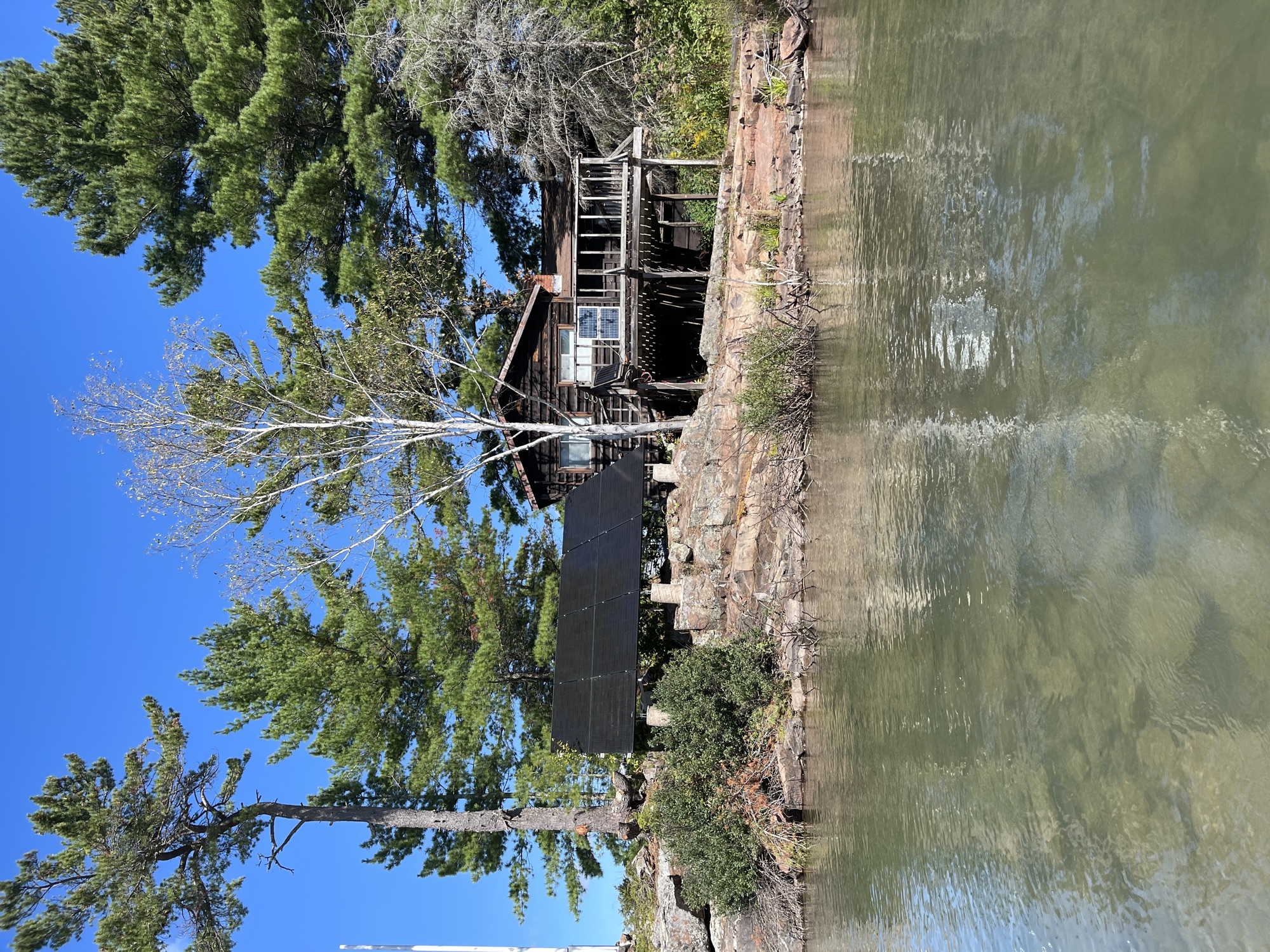 Off-grid solar panels beside a lakeside cabin in the Algoma region