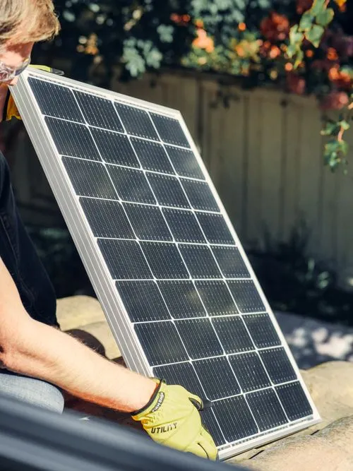 Solar technician handling a photovoltaic panel